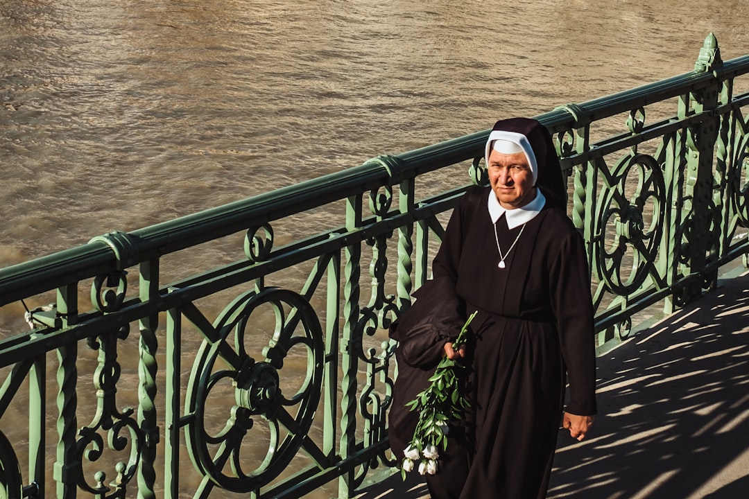 nun walking near the ocean,