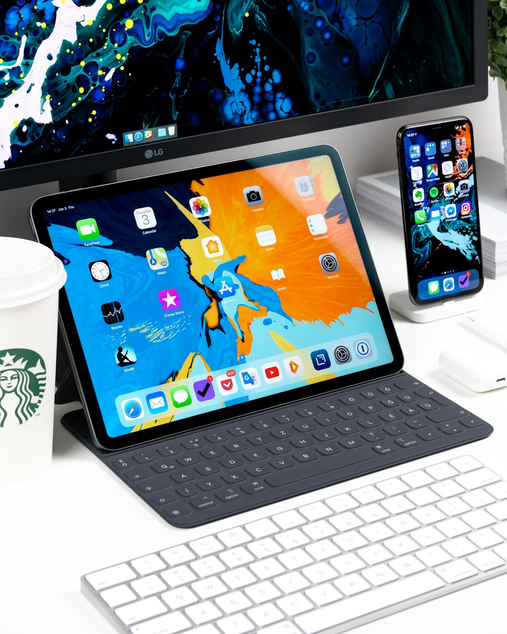 black iPad near the white keyboard