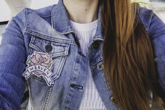 woman wearing blue denim faded jacket with patches