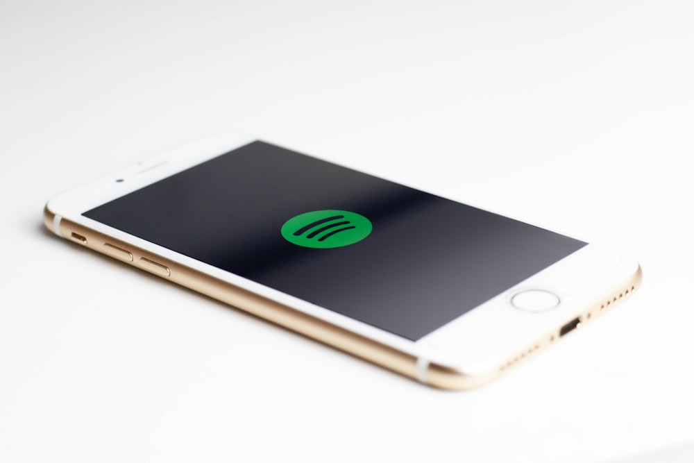 Spotifyのロゴを表示するゴールドのiPhone7