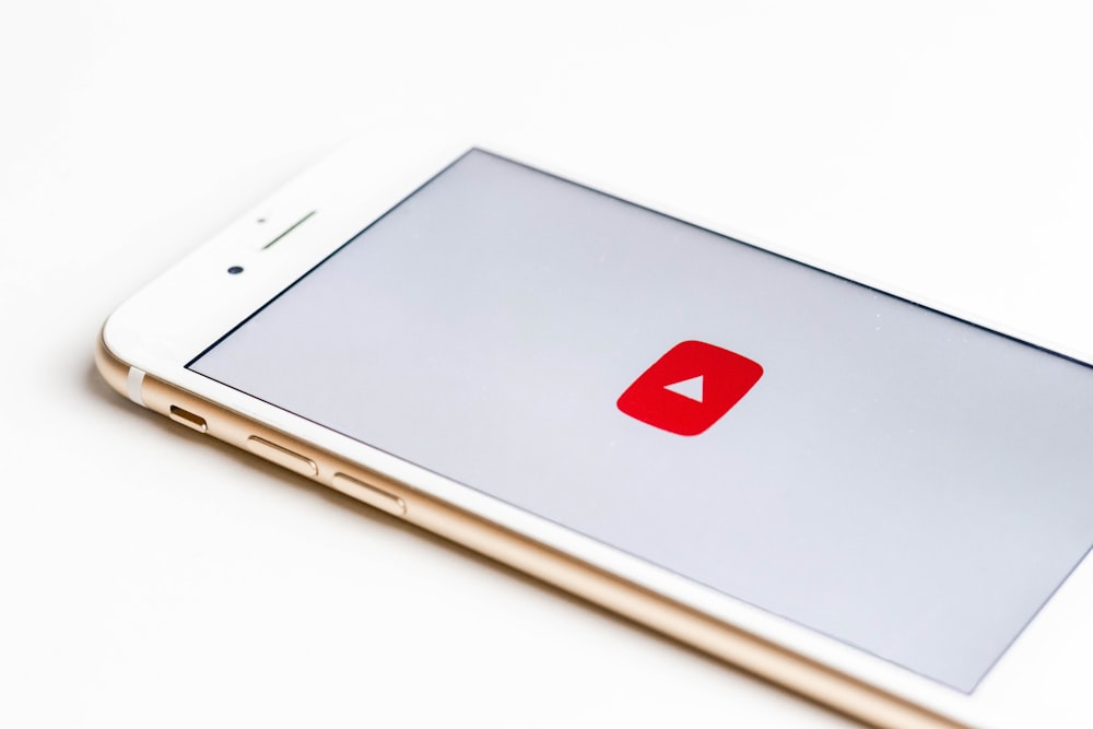 White smartphone displaying YouTube icon