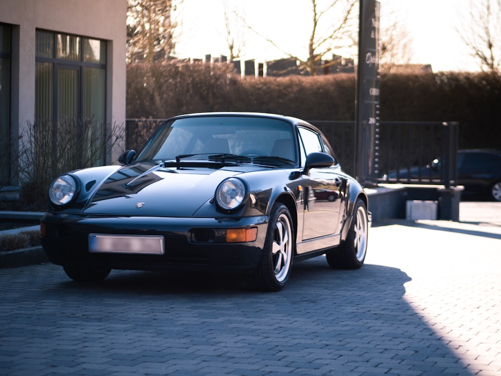 black Porsche 911 parked in front of house