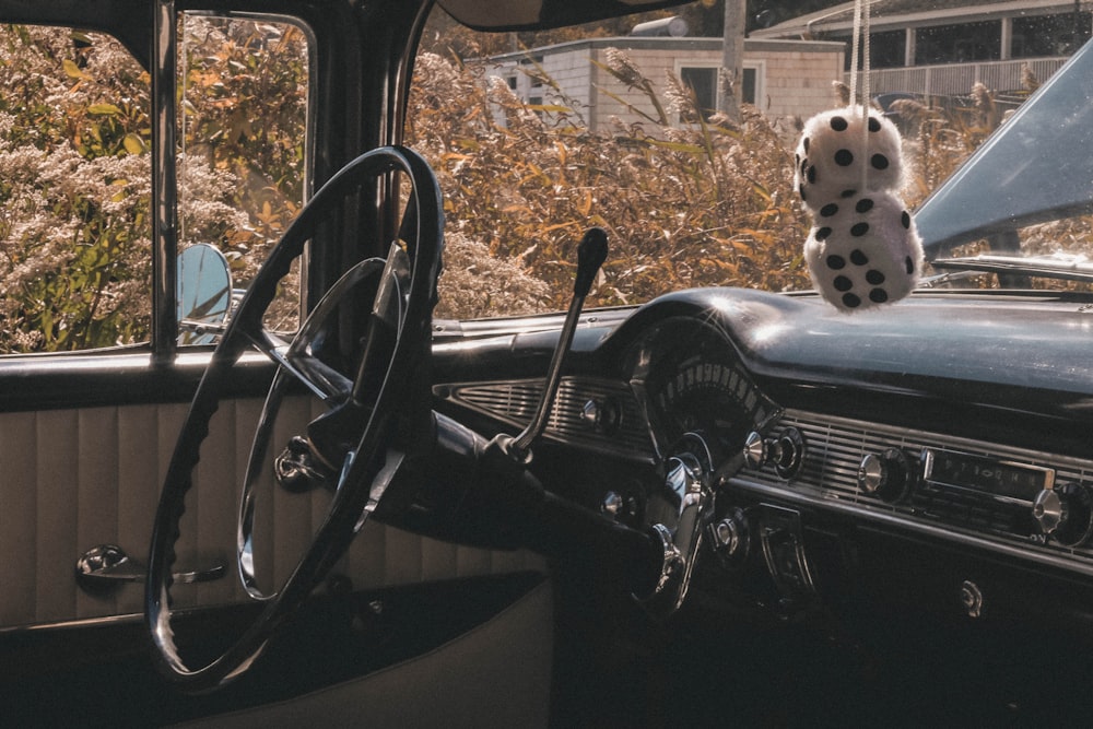 a dalmatian dog sitting on the dashboard of a car