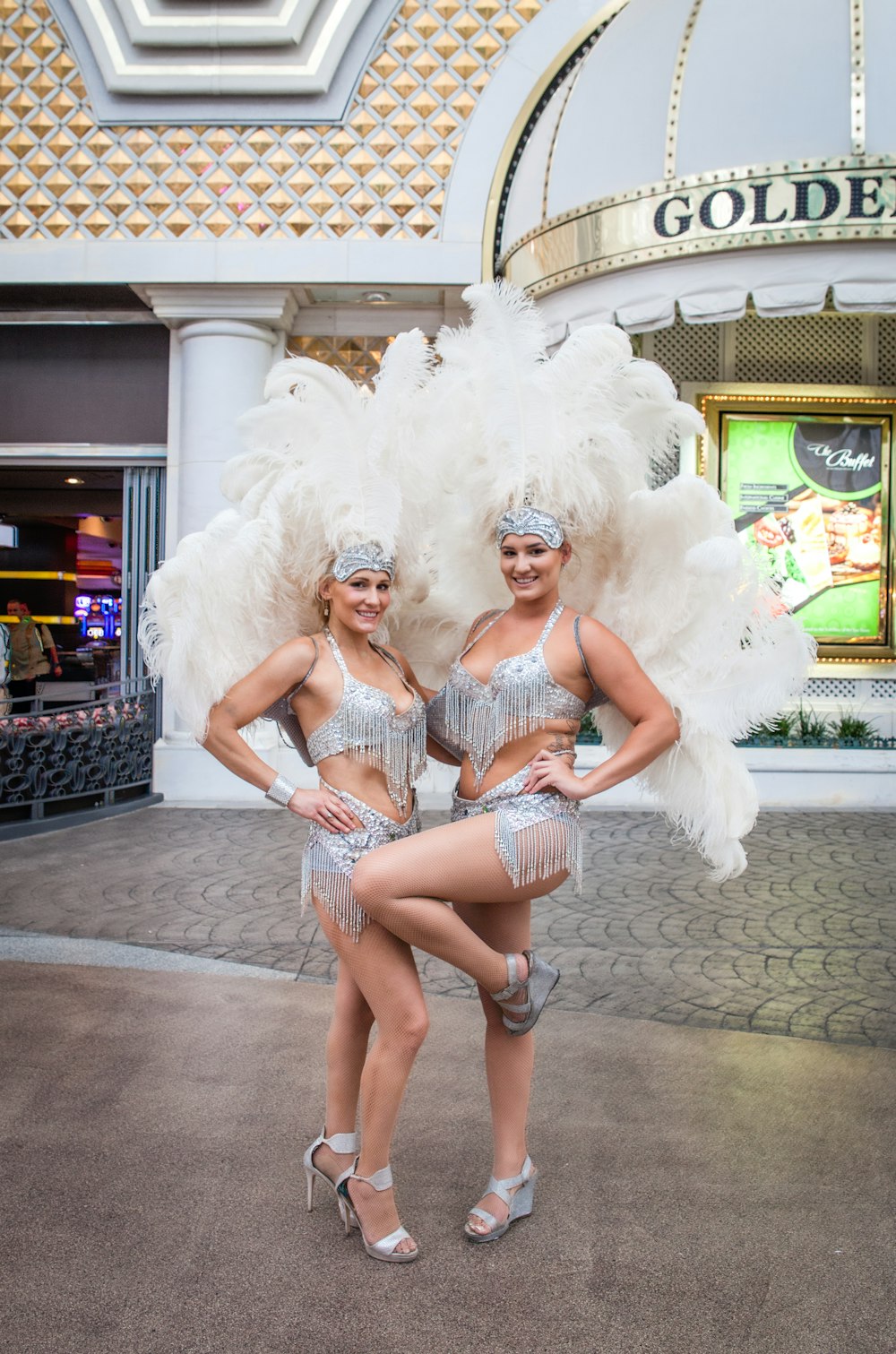 two women wearing feather head dress