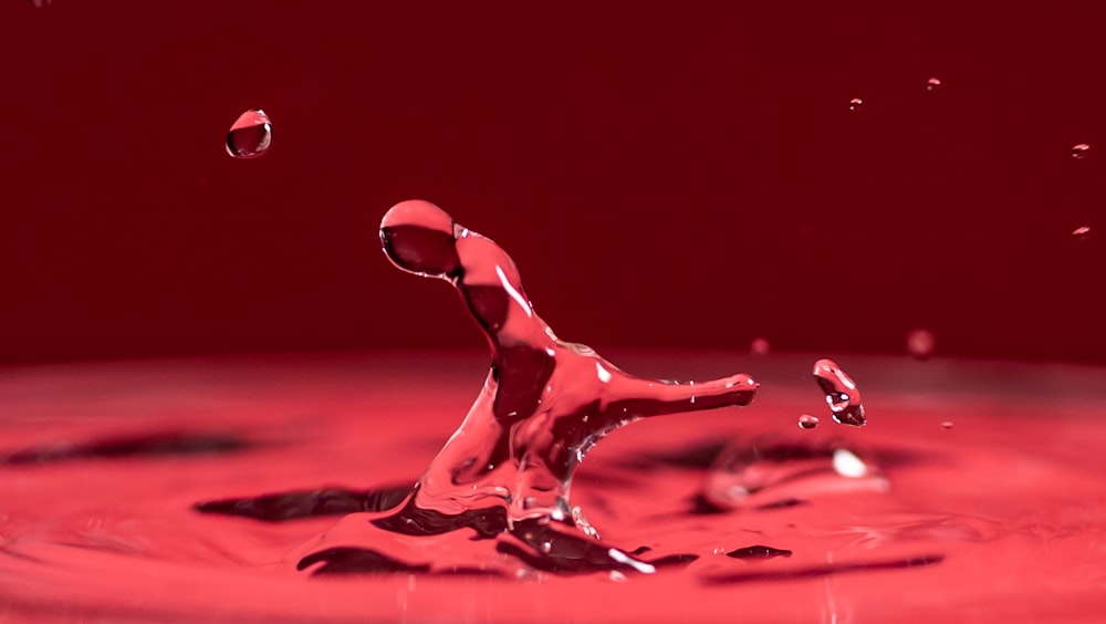 una gota de agua que está cayendo en un tazón rojo