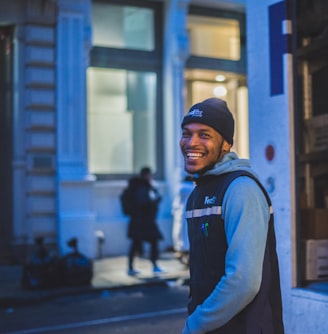 smiling man stands behind delivery truck