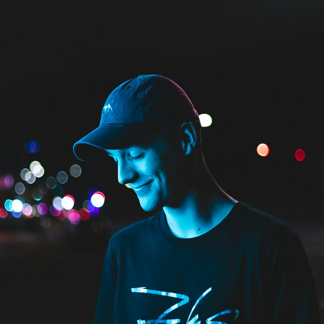 man wearing curved-brimmed cap and black shirt