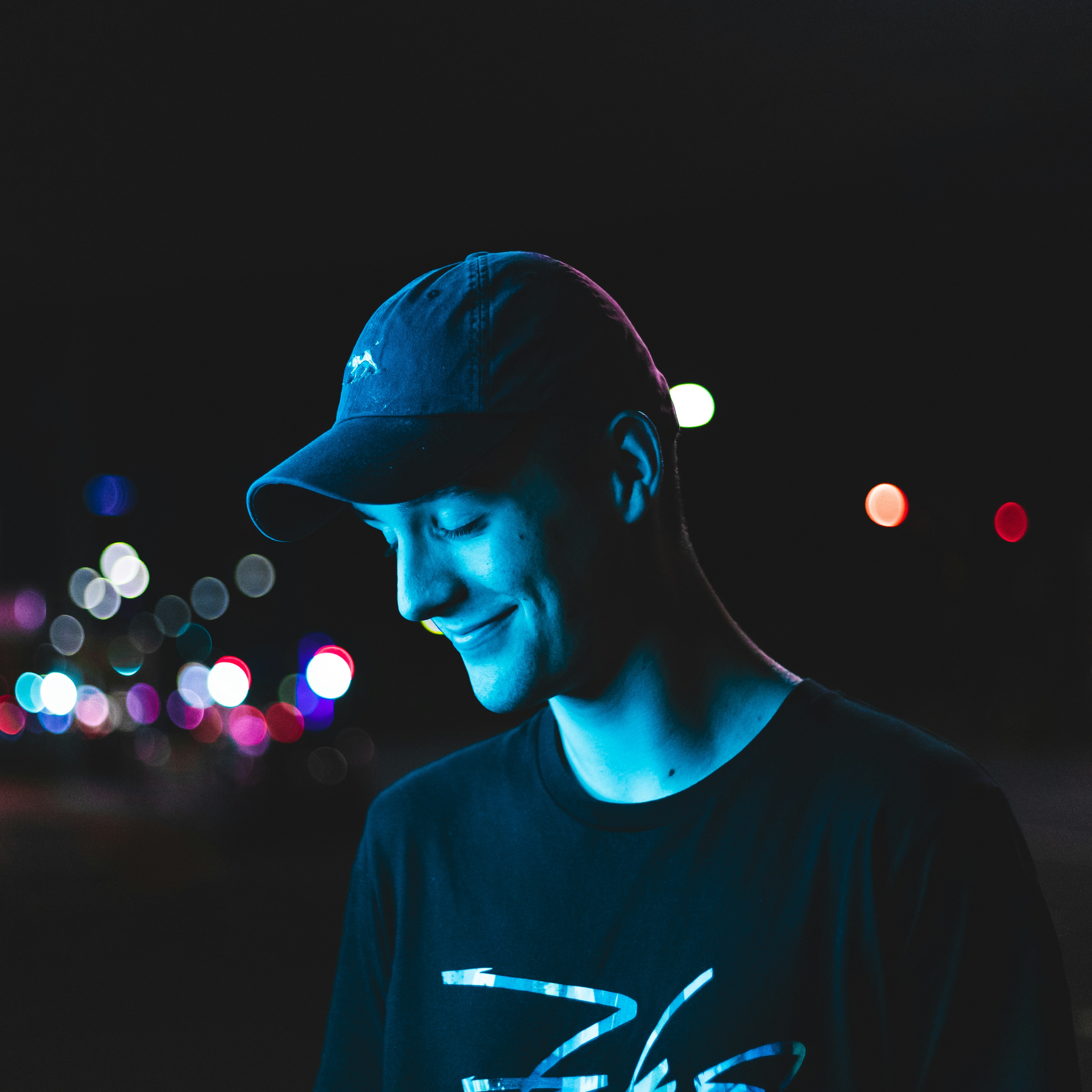 man wearing curved-brimmed cap and black shirt