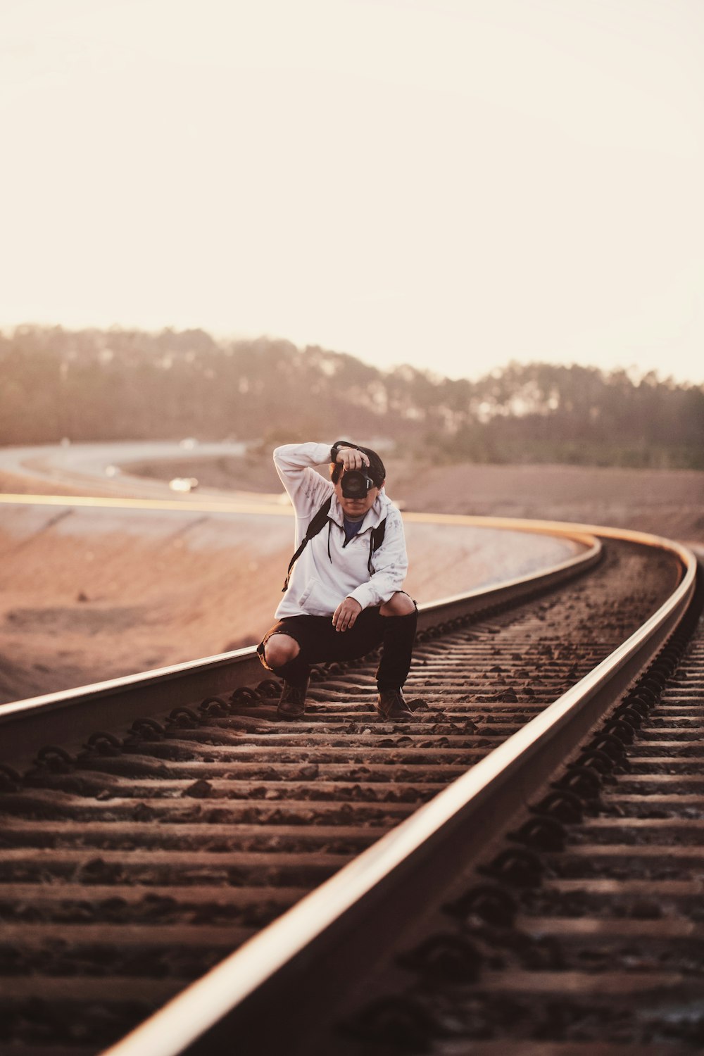 man on railroad taking pictures with camera