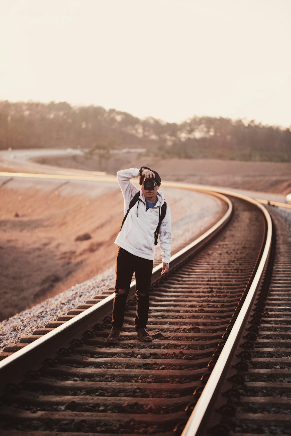 man standing on train railway