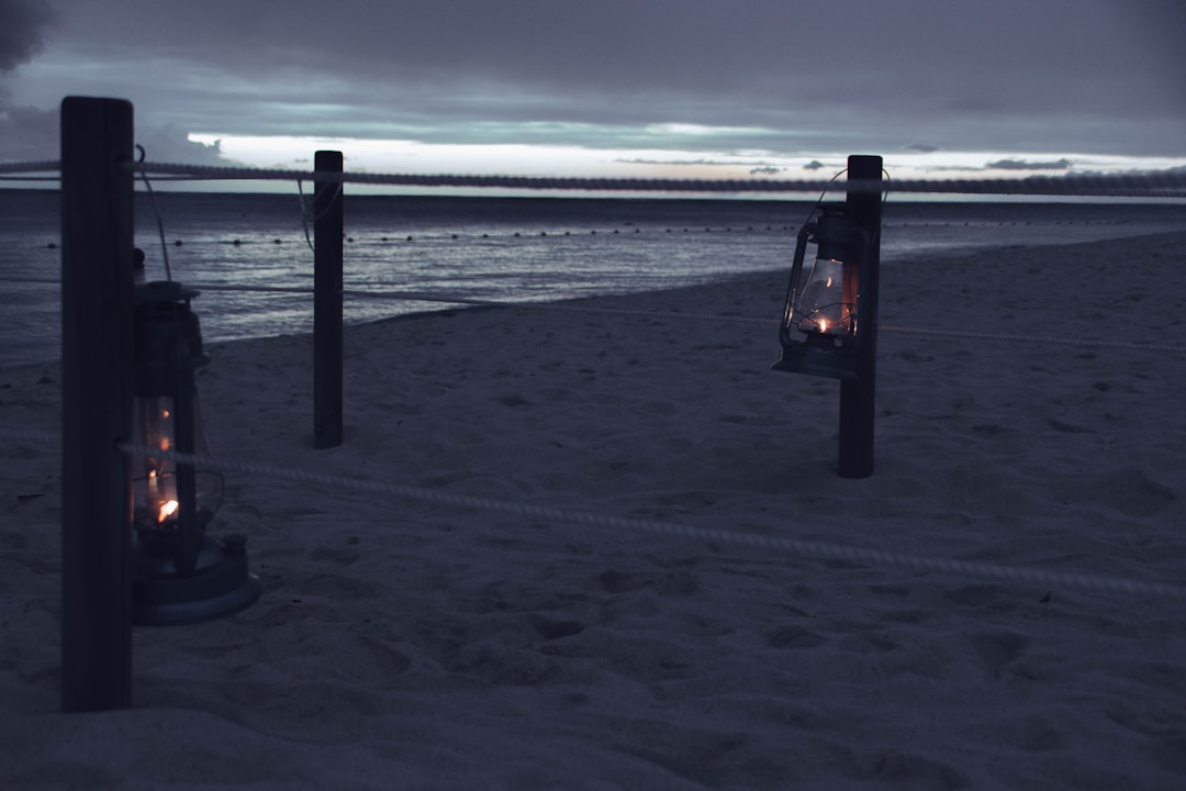 two lantern lamps on seashore