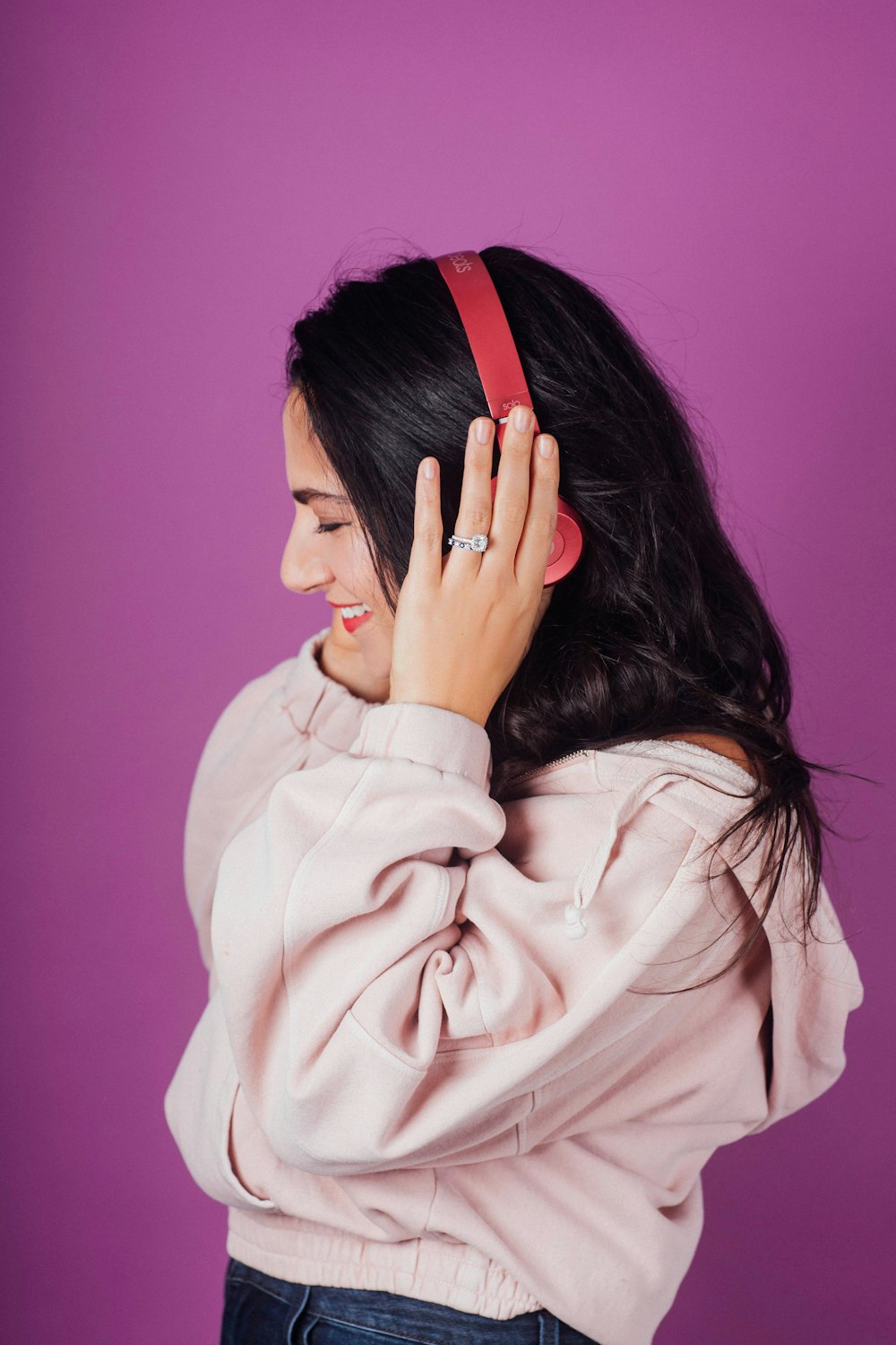 woman in white top holding her headphones