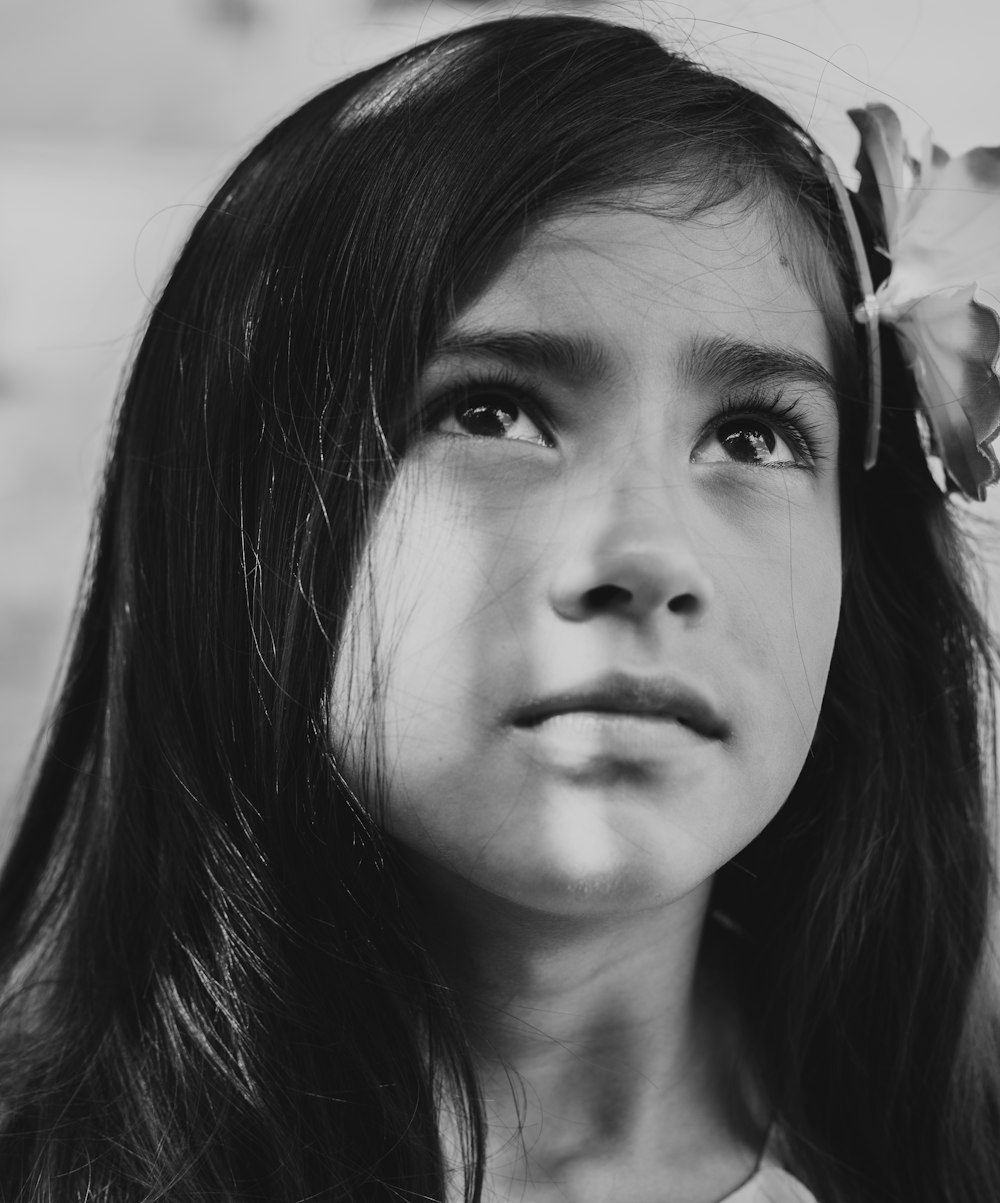 grayscale photography of girl with flower on head