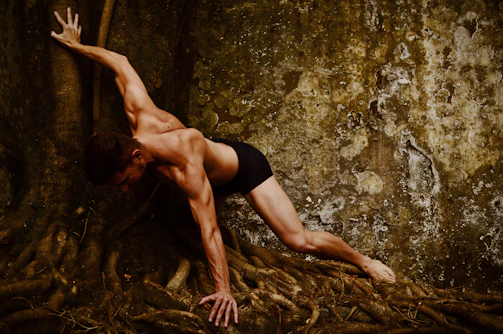 Liam demonstrating a powerful standing pose outdoors with a forest background.