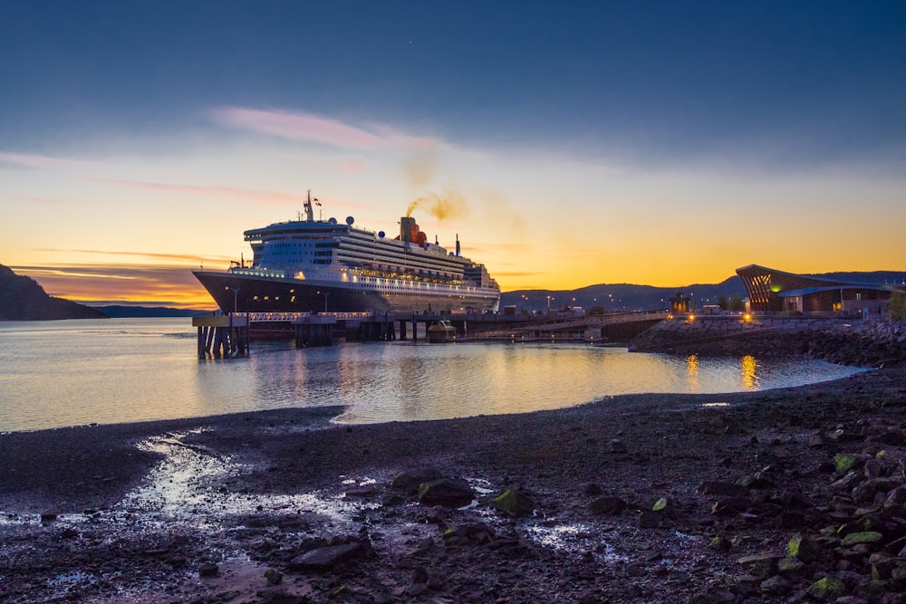 ship on dock under blue and red sky during sunset