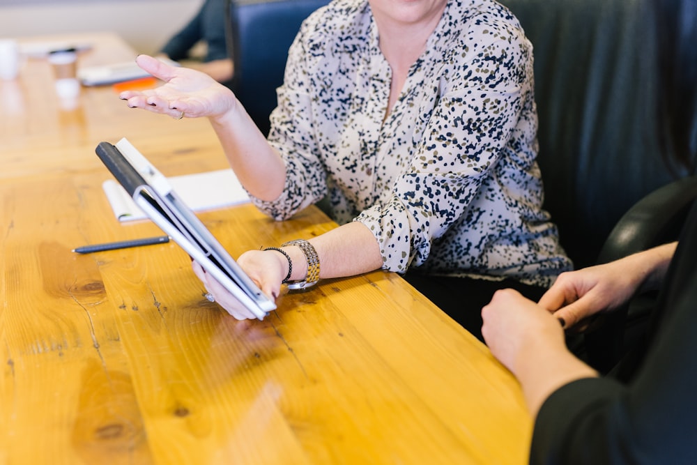 woman holding tablet computer showing to seatmate