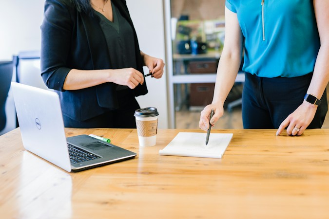 A real estate professional reviewing listing pricing documents with homeowners at a kitchen table