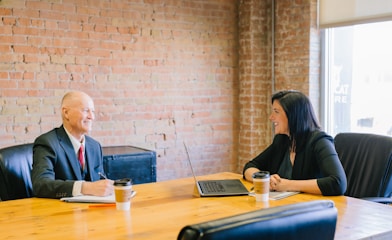 man and woman talking inside office