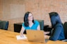 woman in teal t-shirt sitting beside woman in suit jacket