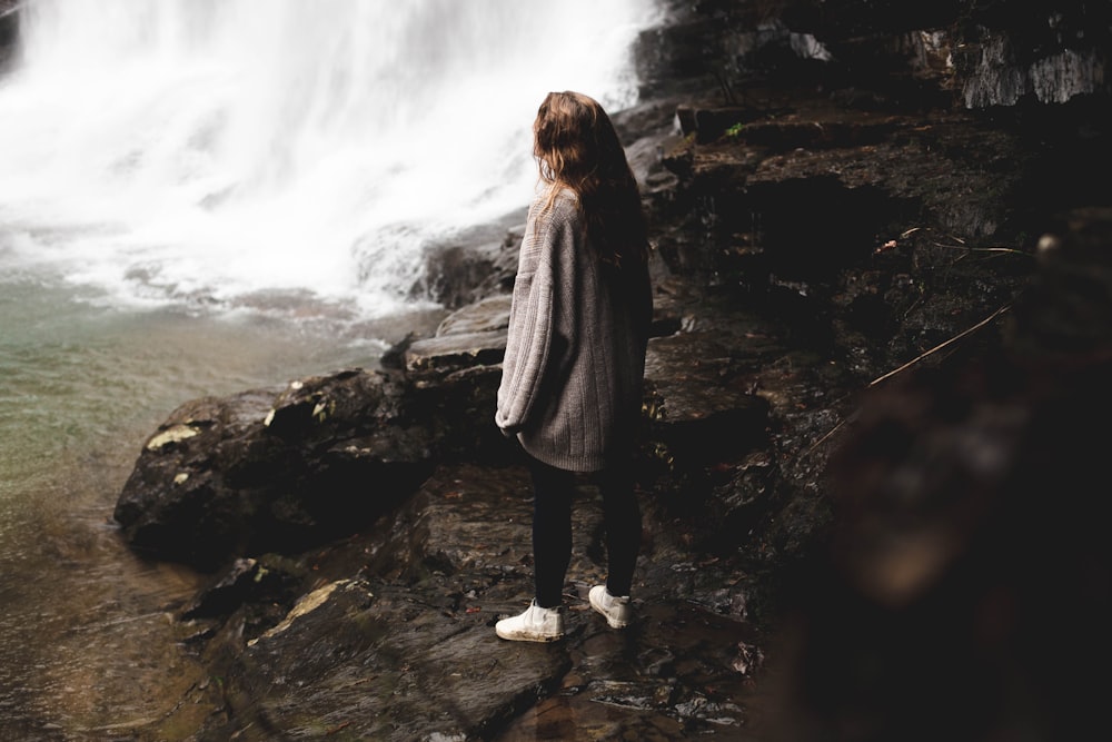 woman standing in the front of waterfalls