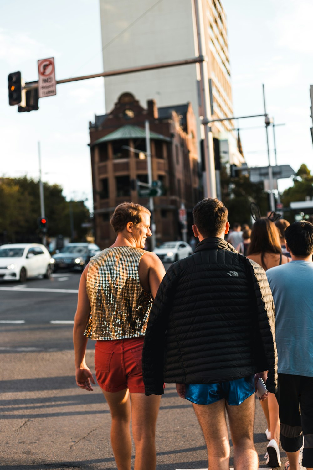 two men walking on street in front of traffic light