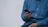 person in blue denim jacket holding smarthone
