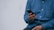 person in blue denim jacket holding smarthone
