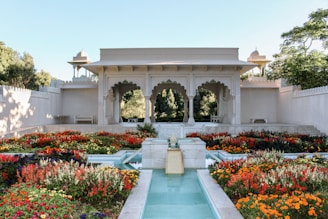 Ancient Mughal gardens with stone pathways and flowing water channels under a clear blue sky.