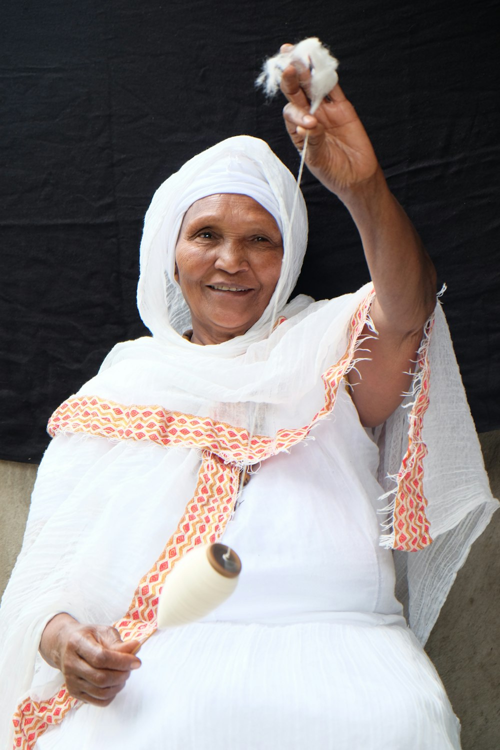 woman holding white thread spool