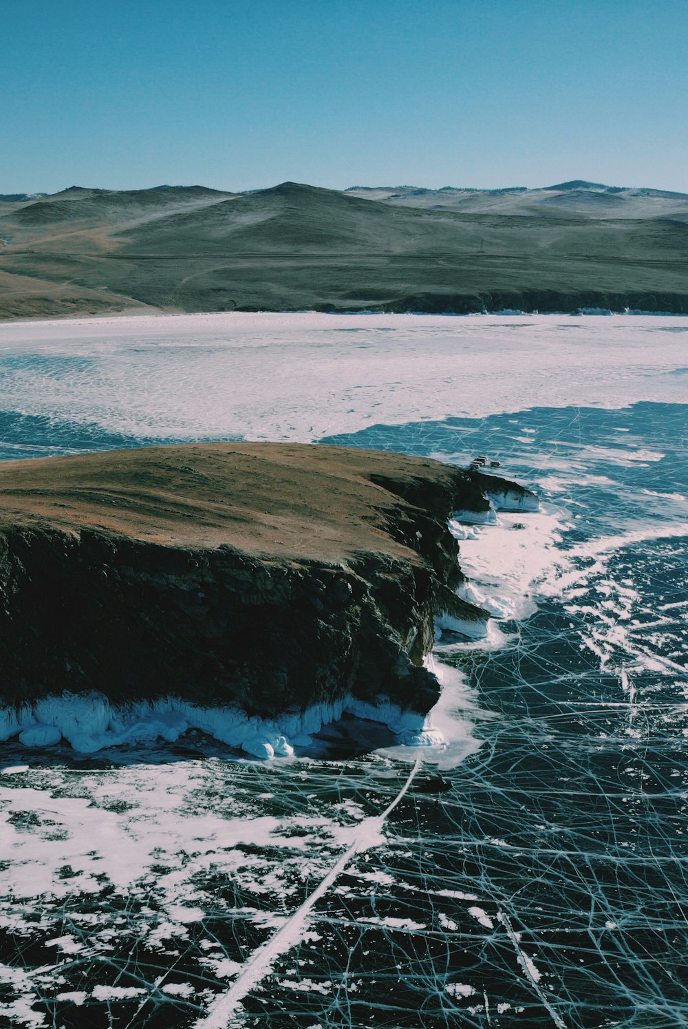 Ondas do mar espirrando através de rochas perto da formação rochosa