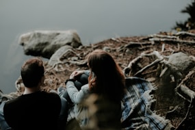 couple sitting near the body of water