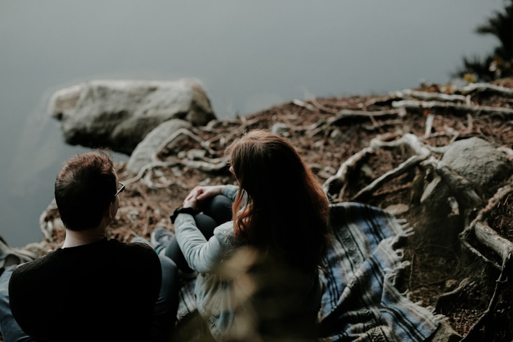 couple sitting near the body of water