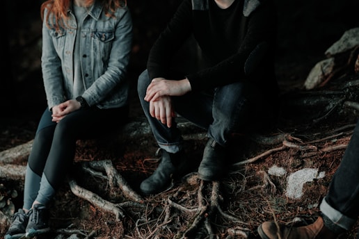 two person sitting on wood slab