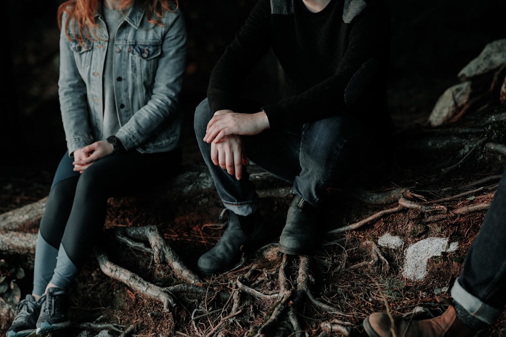 deux personnes assises sur une dalle de bois