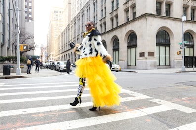 A model wearing a bold, avant-garde outfit walking confidently on a city street.