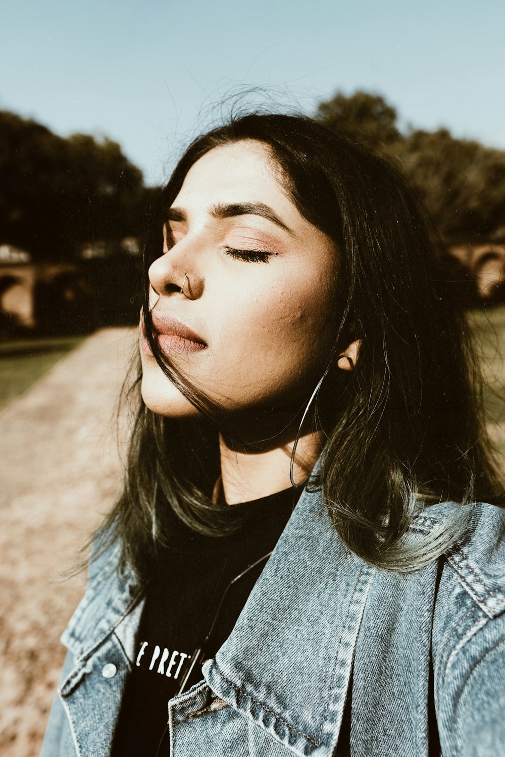 femme portant une chemise noire et une veste en jean bleue