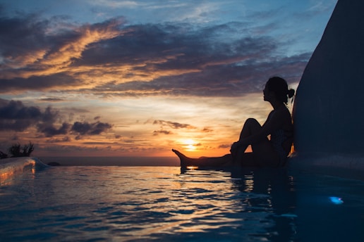 woman sitting on pool during daytime