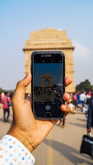 A traveler happily exploring a famous city landmark with a smartphone in hand.