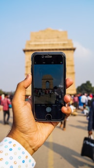 A traveler happily exploring a famous city landmark with a smartphone in hand.