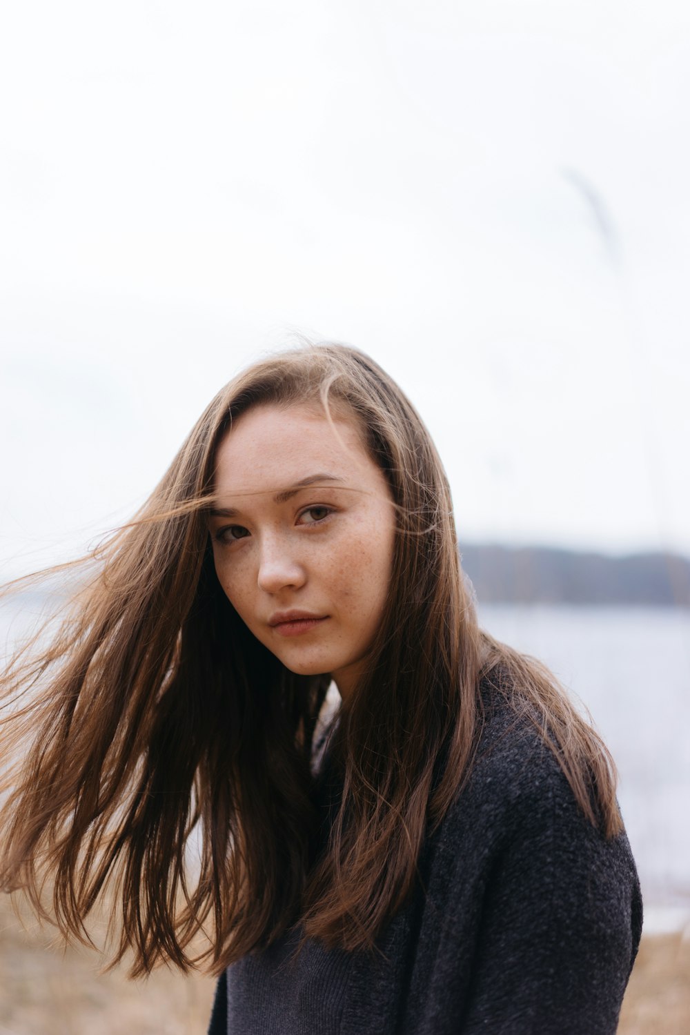 woman in black sweater on shore during daytime