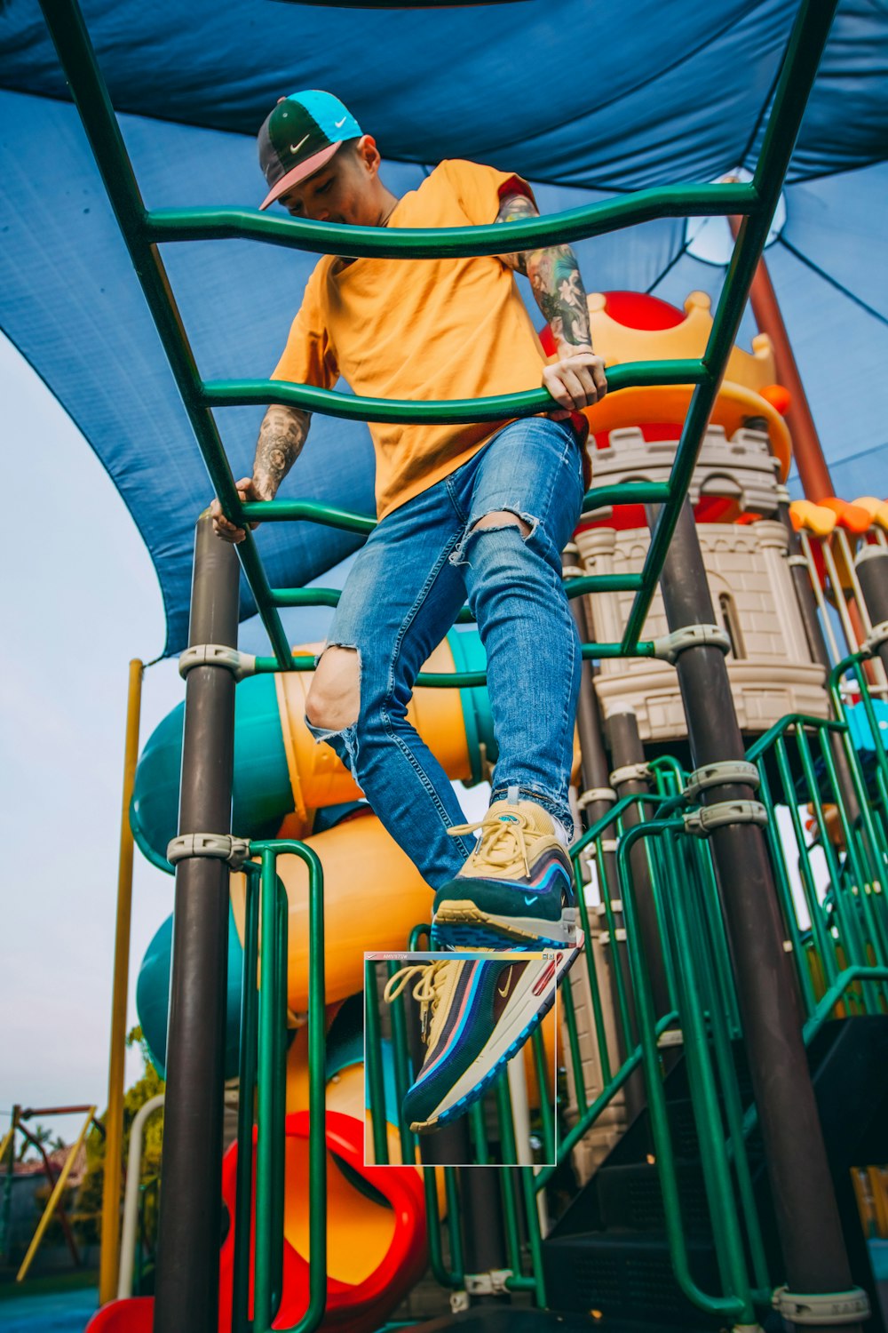 man hanging on green monkey bar