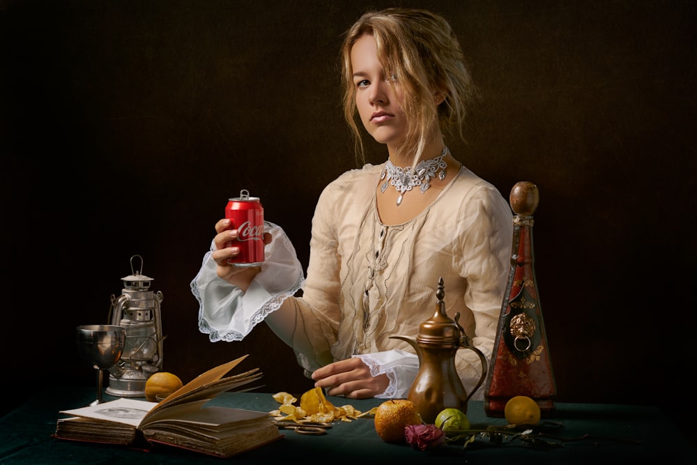 woman holding Coca-Cola can while sitting at the table