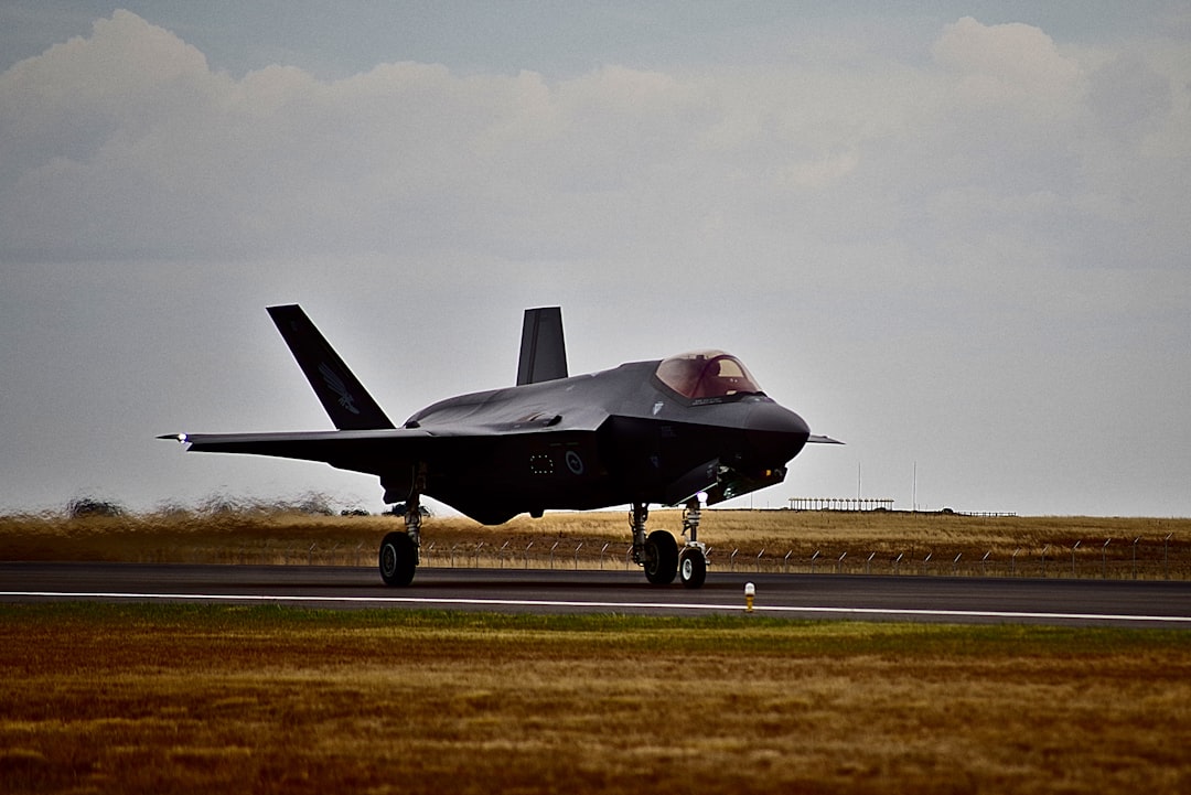 black fighter plane on road,