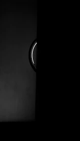 Minimalist black door with subtle chrome details illuminated by warm, cinematic light.