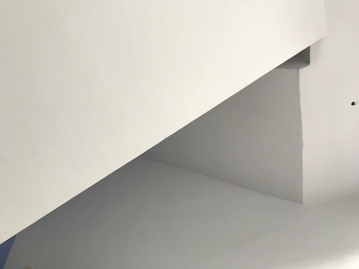 A minimalist architectural sketch with warm off-white and charcoal grey tones.