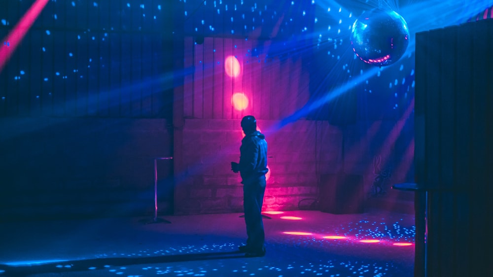 a man standing in front of a disco ball