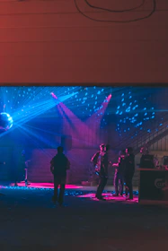 A vibrant bar lounge with colorful lights and guests enjoying drinks in Douala.