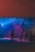 A dimly lit room with colorful lighting casts blue and pink hues across the space. Several people are standing and interacting near a bar area with visible drink logos. A disco ball hangs from the ceiling, reflecting light to create a lively ambiance.
