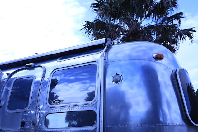 Close-up of a Smartsides trailer clip securely attached to a rugged utility trailer under a bright sunny sky.