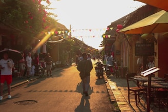 A cozy village street bustling with locals and tourists during a colorful festival